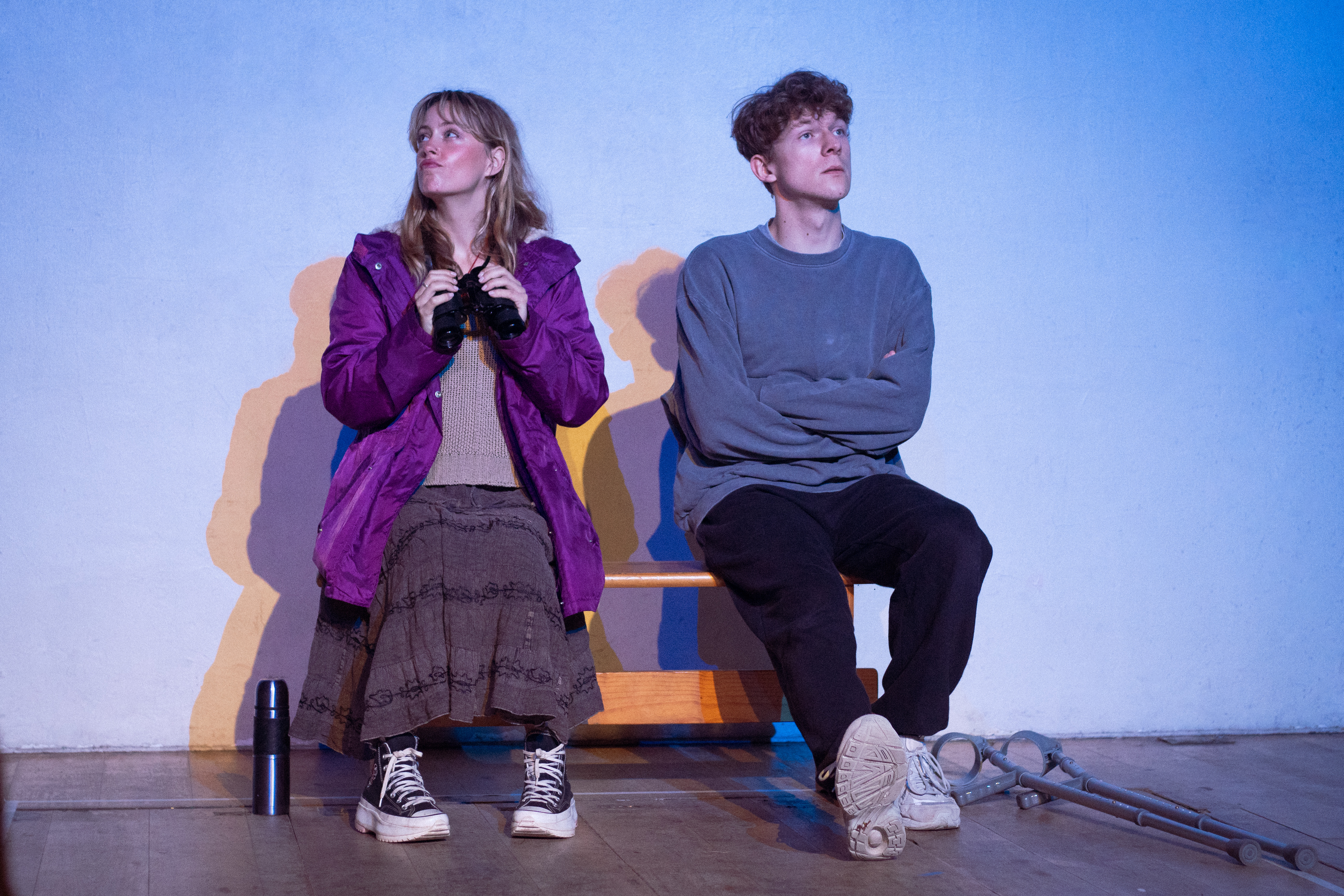 Tech still of actors Andy and Gwithian sitting side by side on a bench.